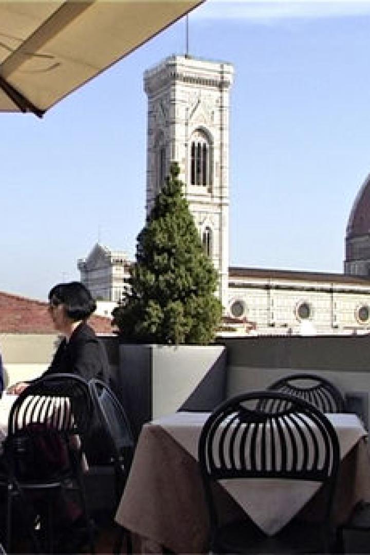 Ein Paar sitzt auf einer Dachterrasse in Florenz mit Blick auf den Dom.
