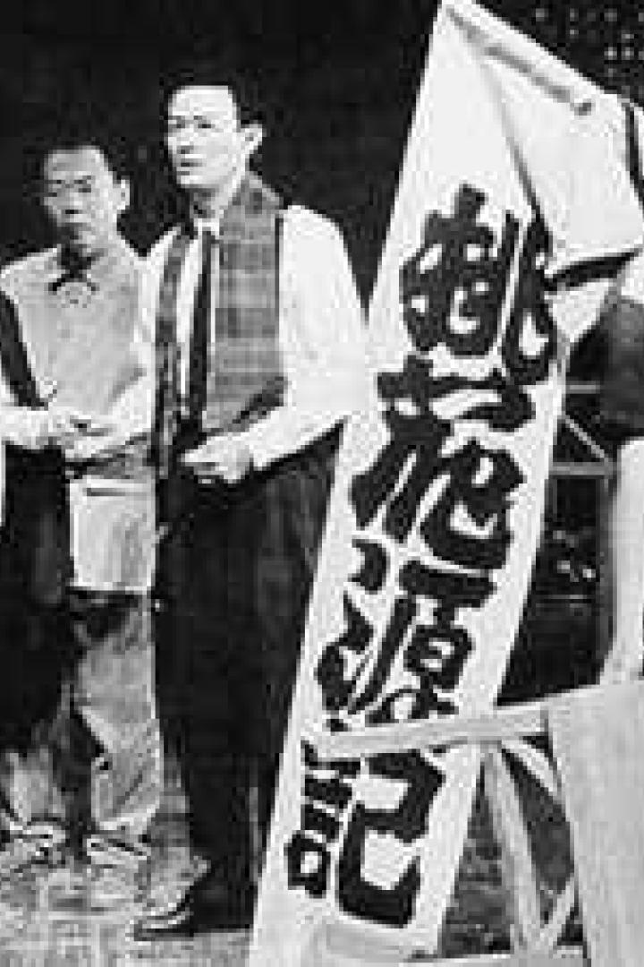 Eine Gruppe japanischer Demonstranten steht mit einem Banner in der Hand.