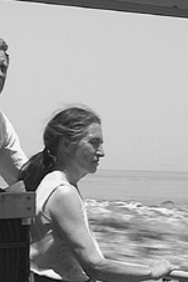 Ein Mann und eine Frau schauen von einem fahrenden Boot auf das Meer.