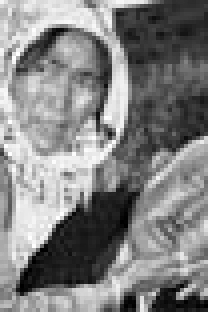 Eine ältere Frau hält den Kopf eines Mannes in ihren Händen.