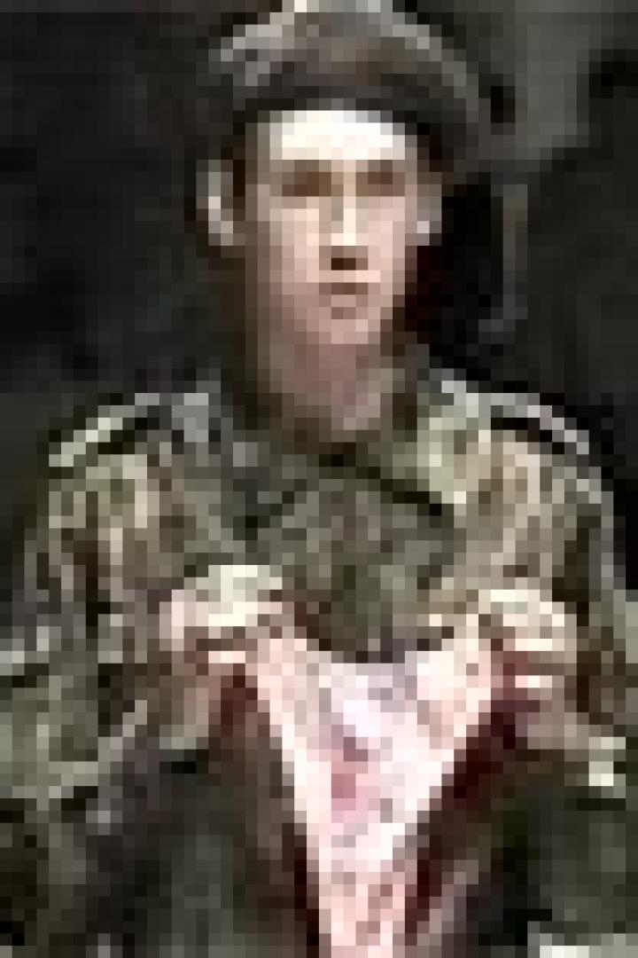 Ein Soldat in Uniform hält eine rosafarbene Unterhose hoch.