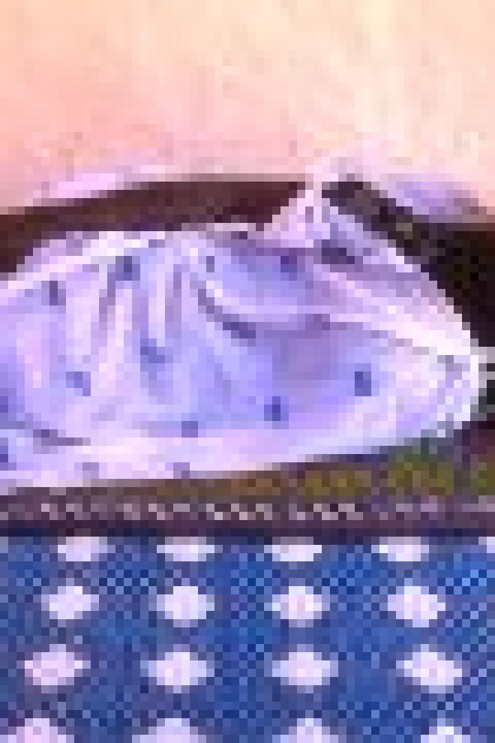 Eine ältere Frau liegt auf einer Matratze.