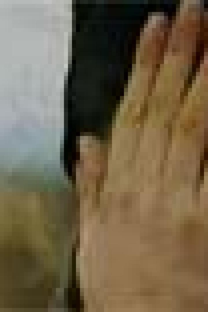 Eine Hand berührt sanft ein Gesicht.