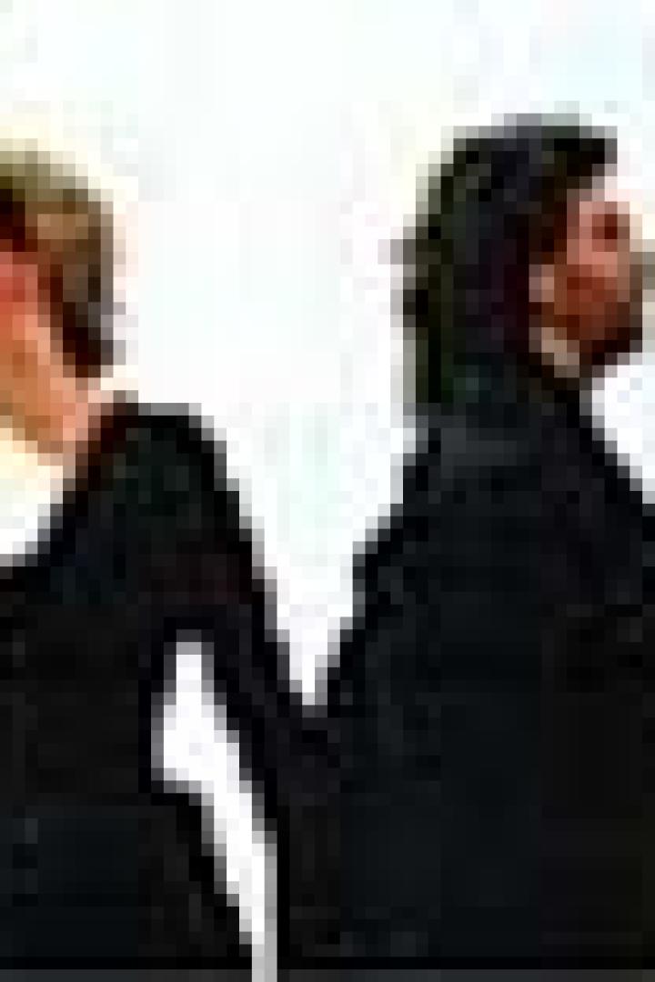 Eine Frau und ein Mann stehen Rücken an Rücken und schauen in unterschiedliche Richtungen.