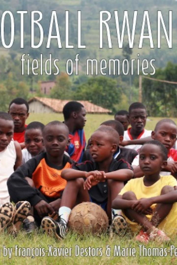 Eine Gruppe junger Fußballspieler sitzt auf einem Feld in Ruanda.