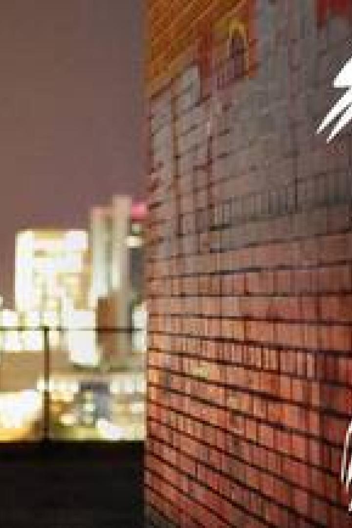 Eine Person sprüht den Titel „The Deepest Depths of the Burrow“ auf eine Ziegelmauer.