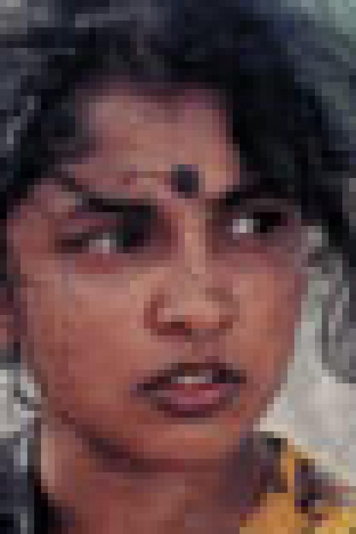 Ein junges Mädchen mit dunklen Haaren und einem Bindi auf der Stirn blickt in die Ferne.