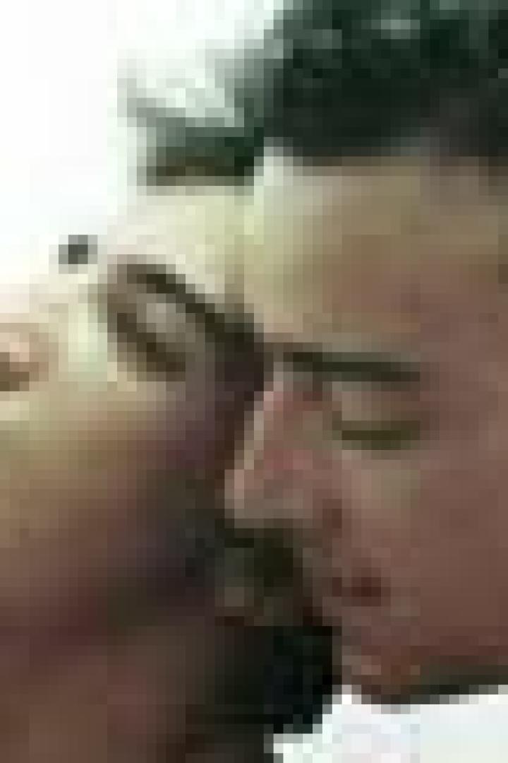 Ein Mann und eine Frau stehen eng beieinander, die Frau mit geöffnetem Mund und zurückgelehntem Kopf.