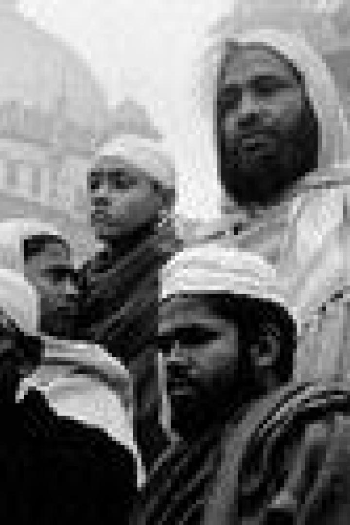 Eine Gruppe muslimischer Männer und Jungen steht vor einer Moschee.