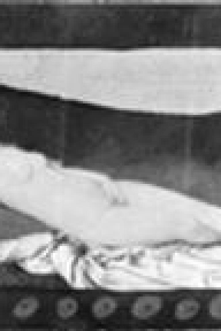 Eine liegende, nackte Frau auf einem Tuch unter einer Wolke.