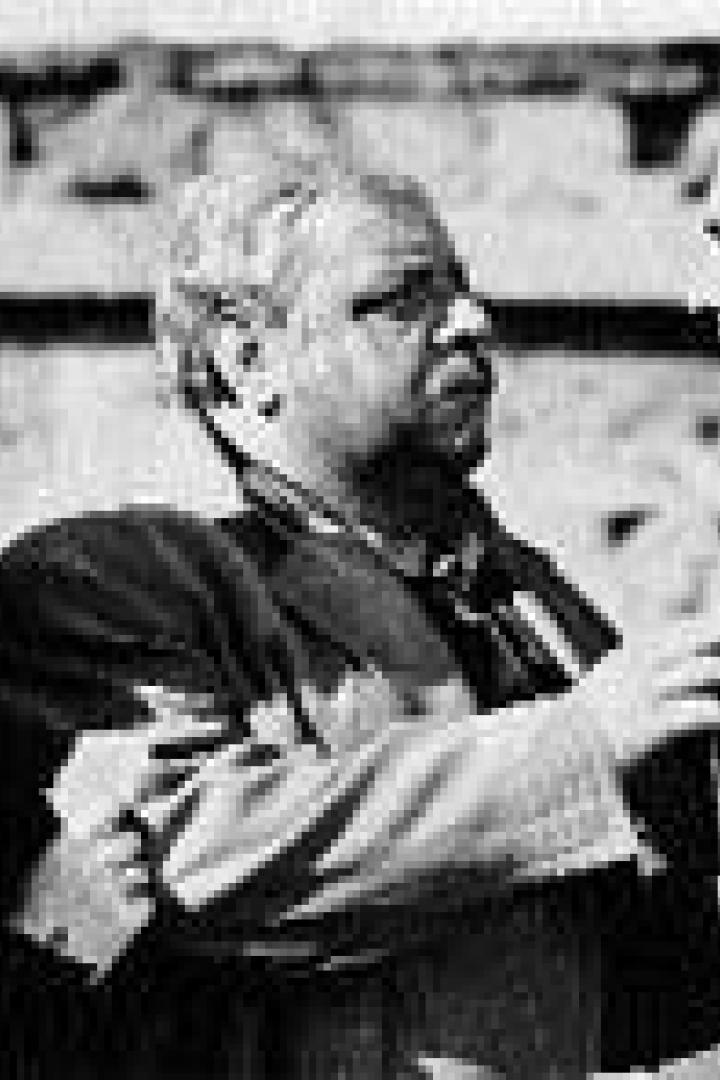 Drei Personen, eine Frau und zwei Männer, stehen in einer Schwarzweißaufnahme zusammen.