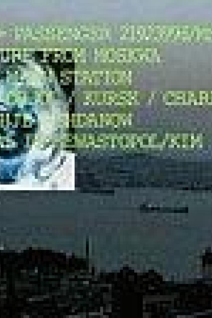 Blick auf eine Stadt am Wasser, mit Zugrouteninformationen im Vordergrund.