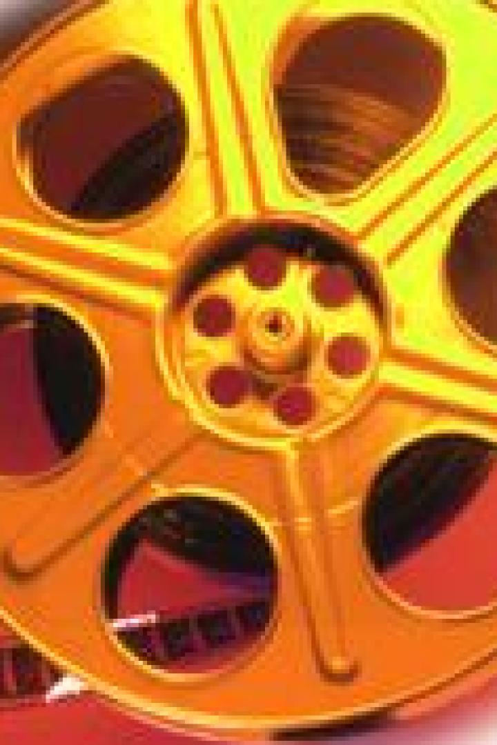Eine goldene Filmrolle mit einem Stück Filmband.