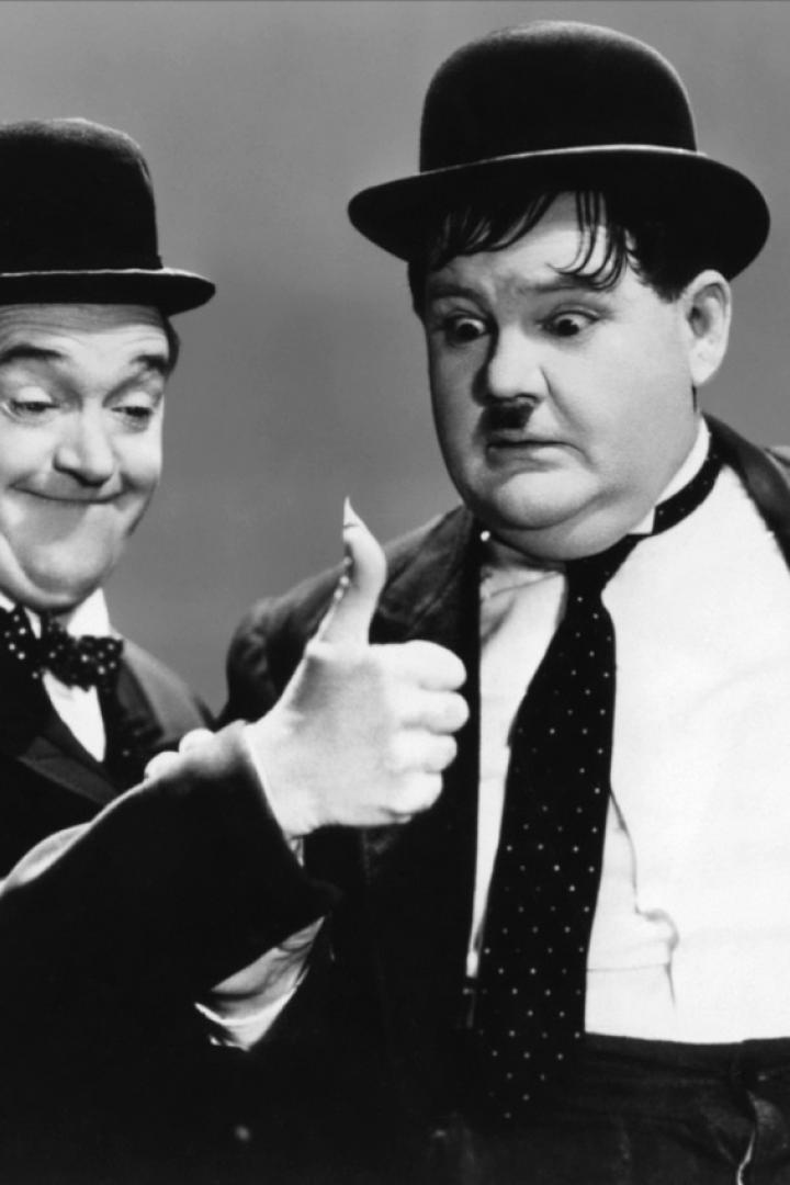 Stan Laurel und Oliver Hardy, bekannt als Laurel und Hardy, geben beide einen Daumen hoch.