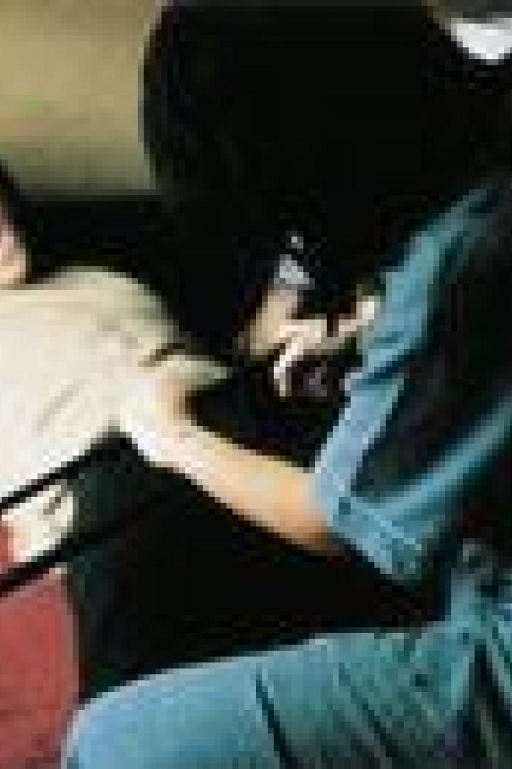 Eine Person in medizinischer Kleidung sägt mit einer Bügelsäge den Arm einer schreienden Person ab.