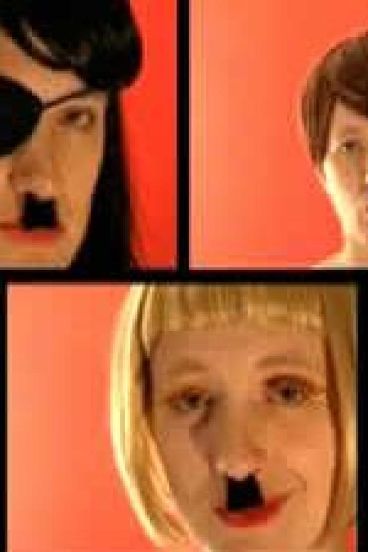 Drei Personen mit aufgemalten Hitler-Bärten vor einem roten Hintergrund.