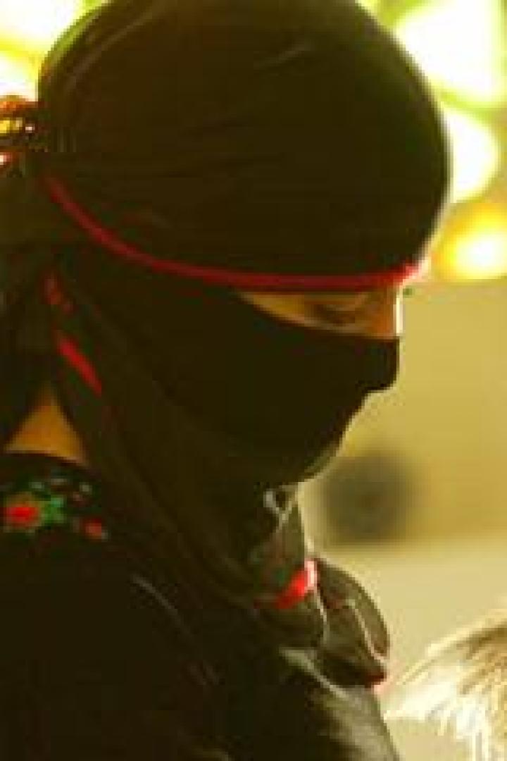 Eine Frau mit schwarzem Niqab blickt nach unten.