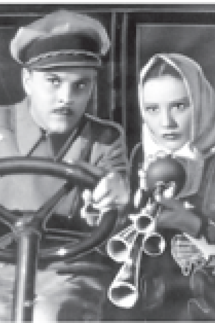 Ein Mann mit Mütze und Uniform und eine Frau mit Kopftuch sitzen in einem Fahrzeug.