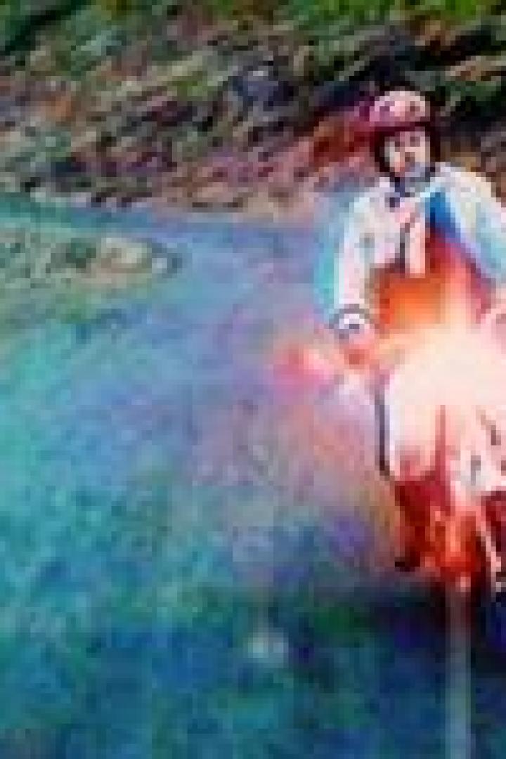 Ein Mann fährt mit einem Motorroller eine kurvenreiche Straße entlang.