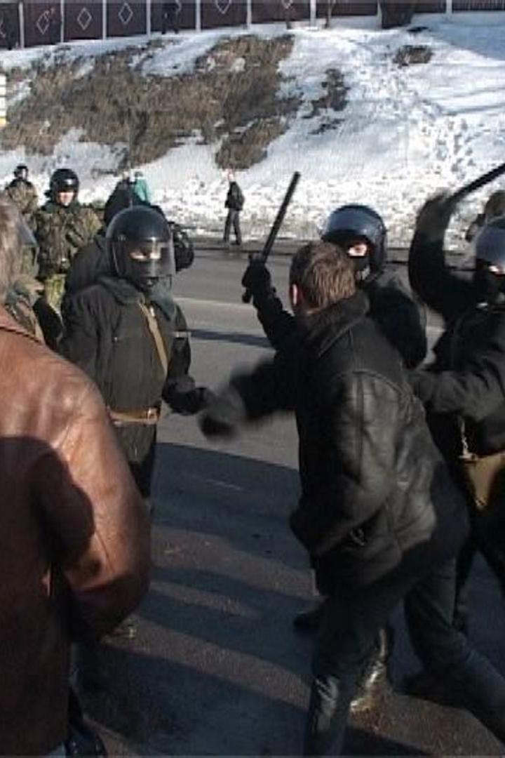 Polizisten in Kampfmontur setzen Schlagstöcke gegen Demonstranten ein.