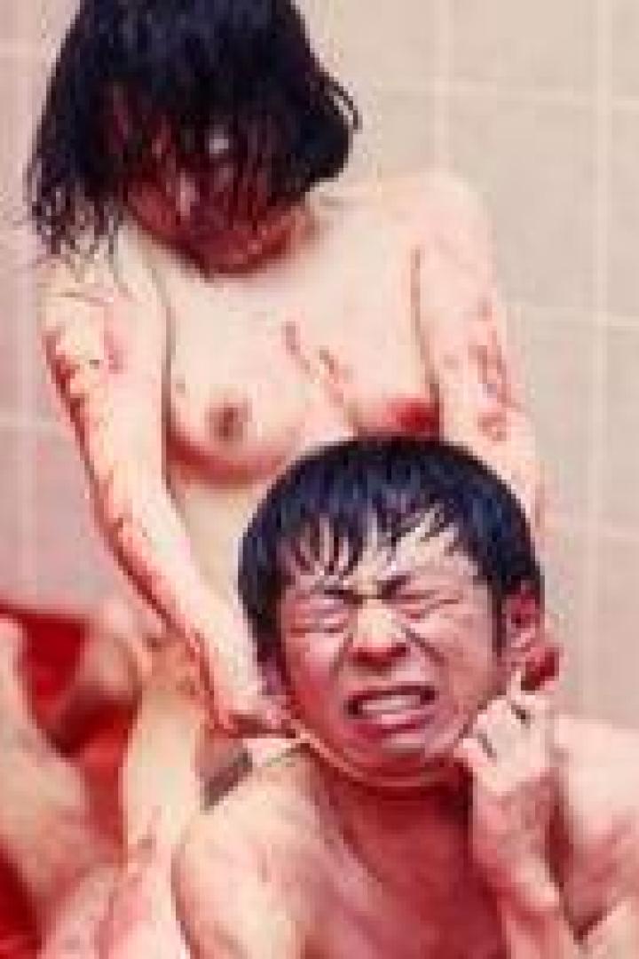 Eine blutverschmierte Frau steht hinter einem Mann und würgt ihn.