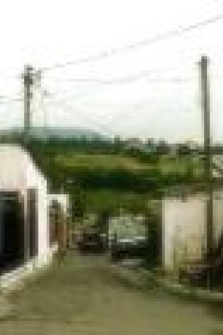 Eine Straße führt durch ein kleines Dorf mit weißen Häusern.