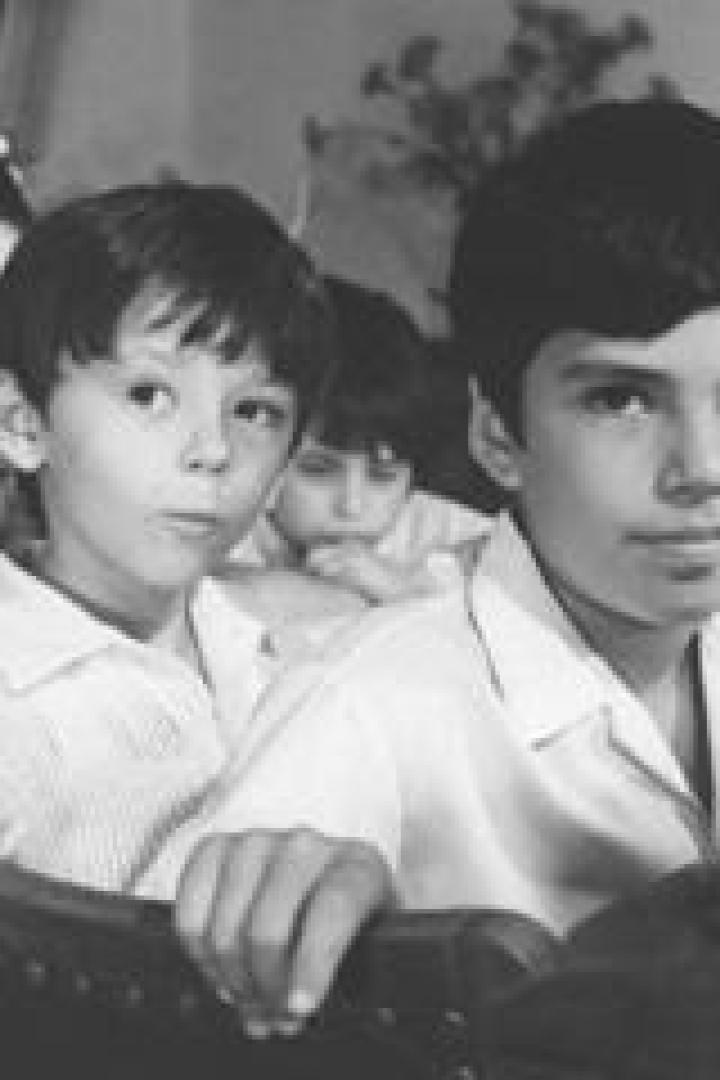 Eine Gruppe von Kindern sitzt an einem Tisch, vermutlich in einem Klassenzimmer.