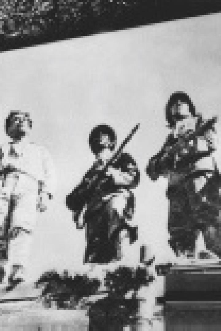 Fünf Soldaten stehen mit Gewehren auf einer erhöhten Plattform.