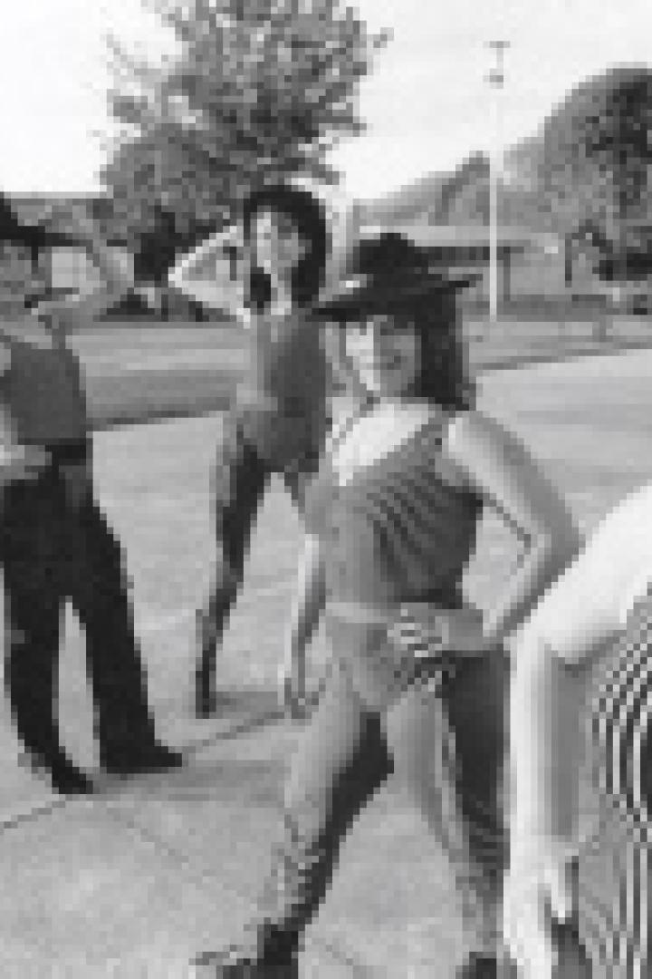 Fünf Frauen posieren in gestreiften Badeanzügen und Hüten im Freien.