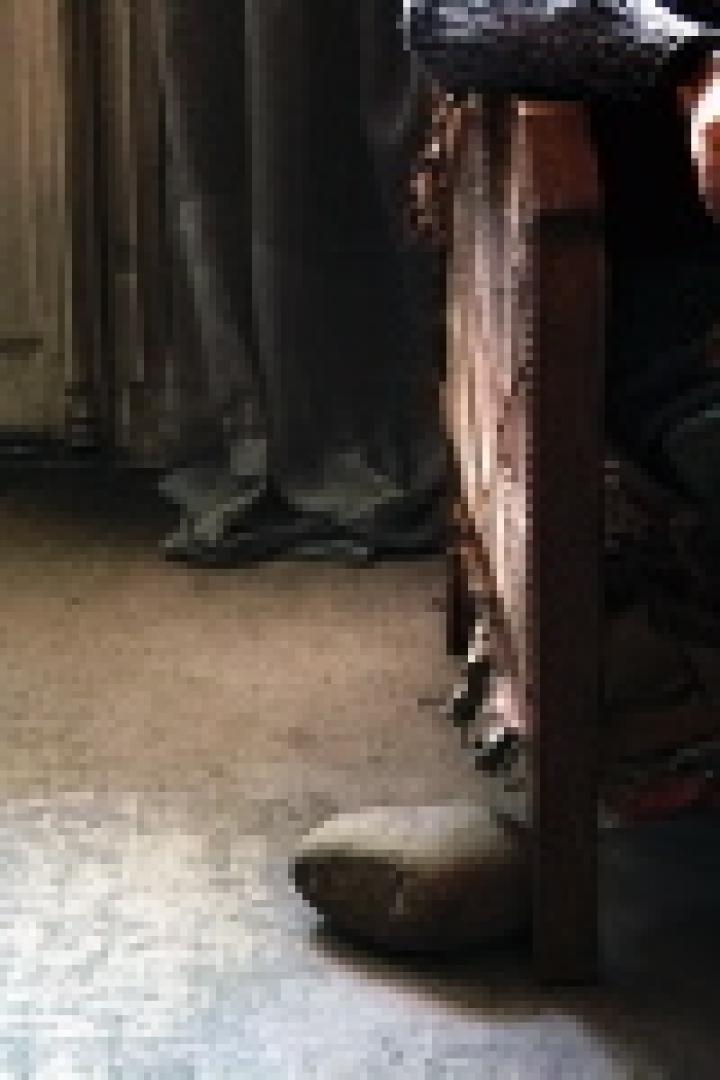 Eine Person sitzt auf einem Stuhl und liest ein Buch.