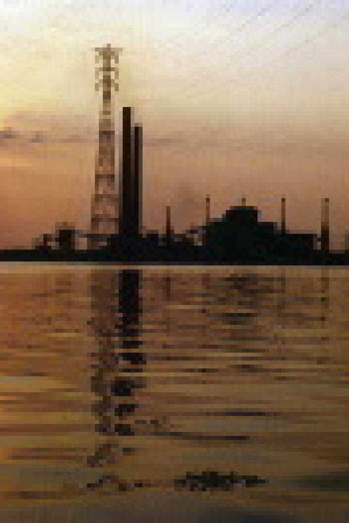 Eine Industrieanlage am Wasser bei Sonnenuntergang.