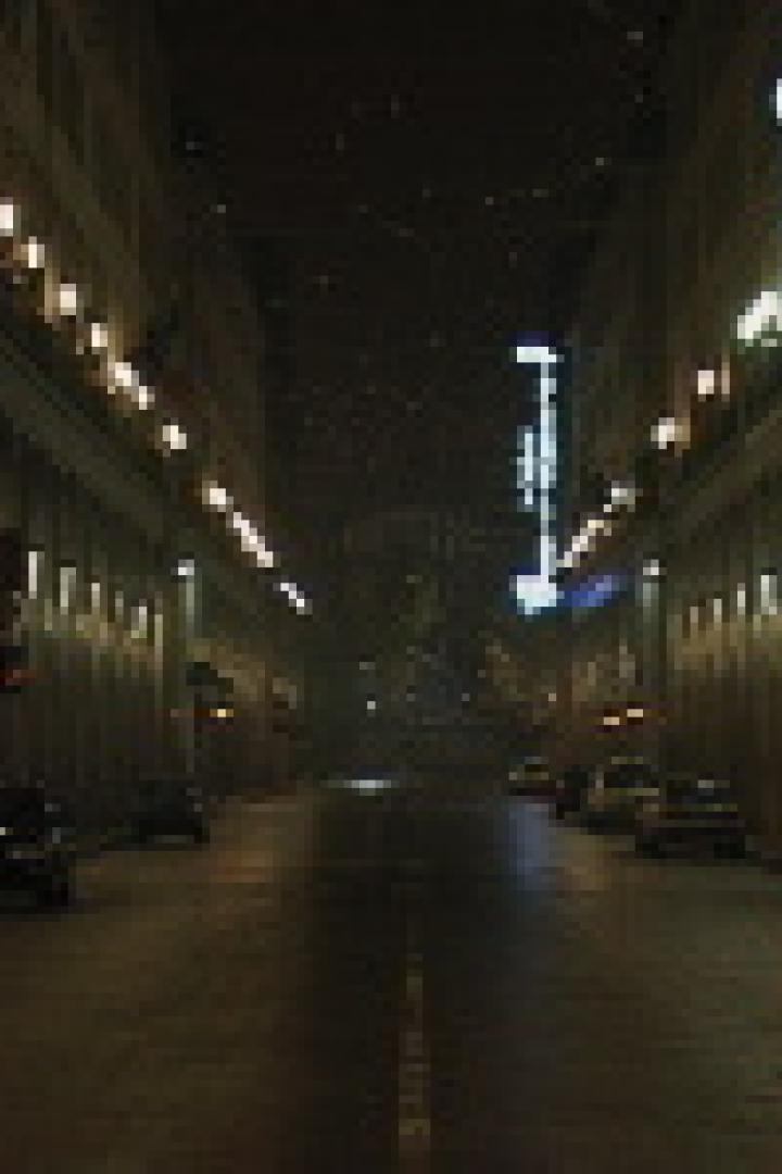 Eine menschenleere Straße in der Nacht mit beleuchteten Gebäuden auf beiden Seiten.