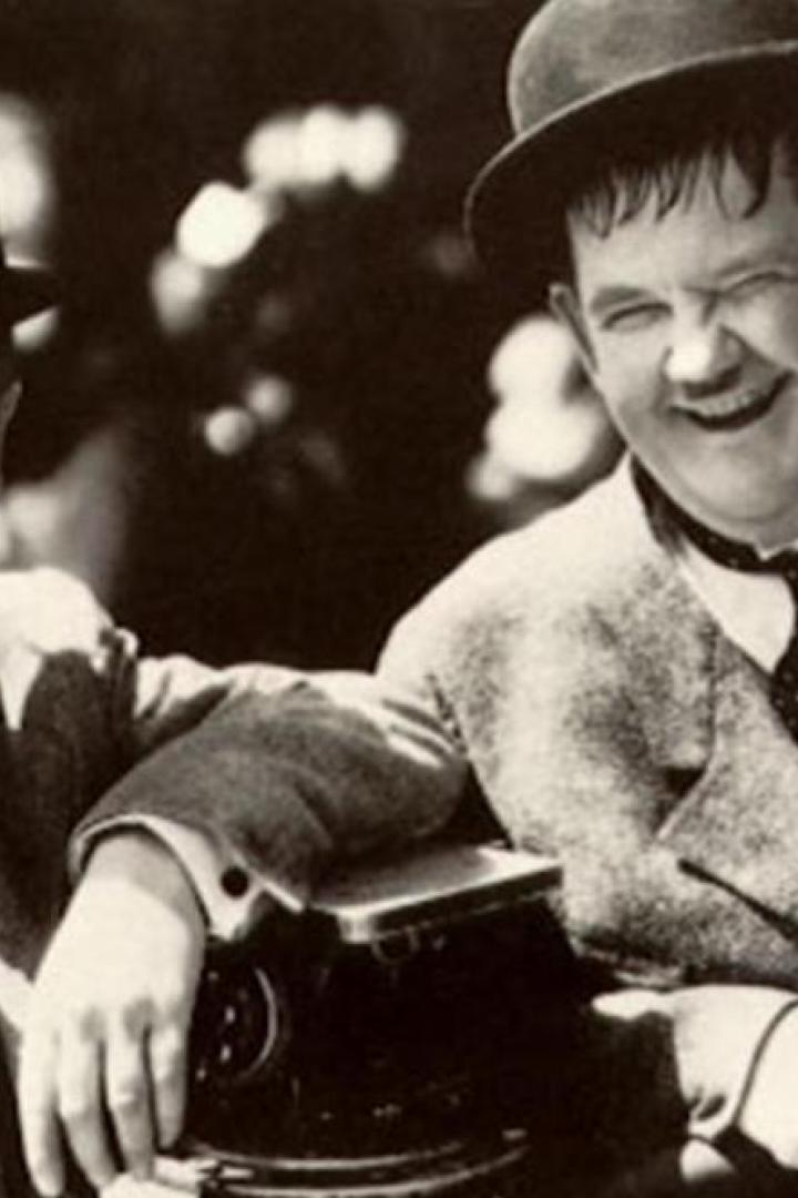 Stan Laurel und Oliver Hardy posieren lächelnd für ein Foto.