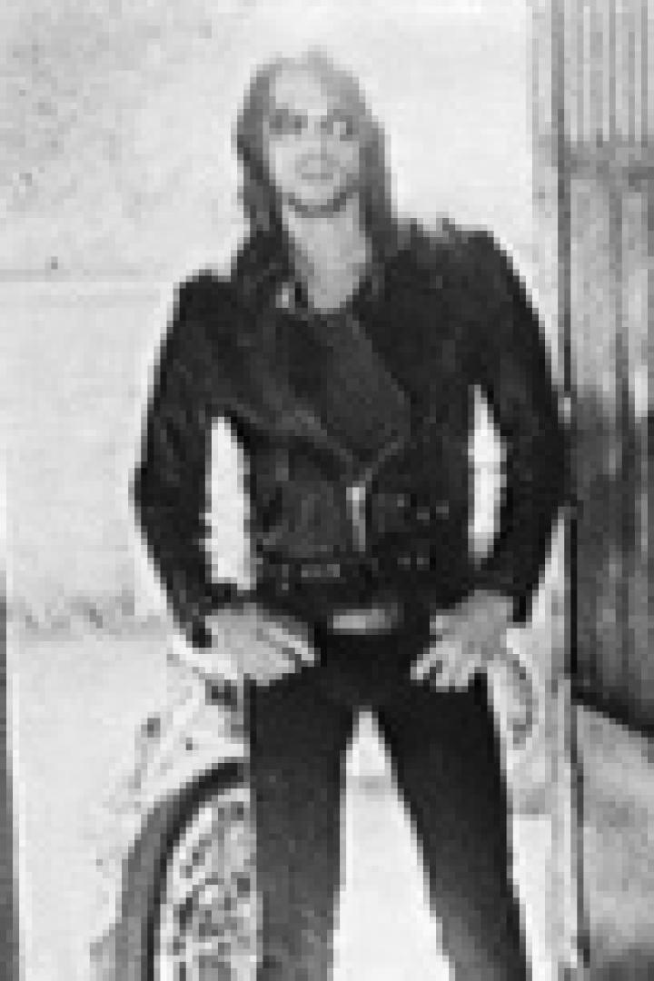 Ein Mann in Lederjacke posiert vor einem Motorrad.