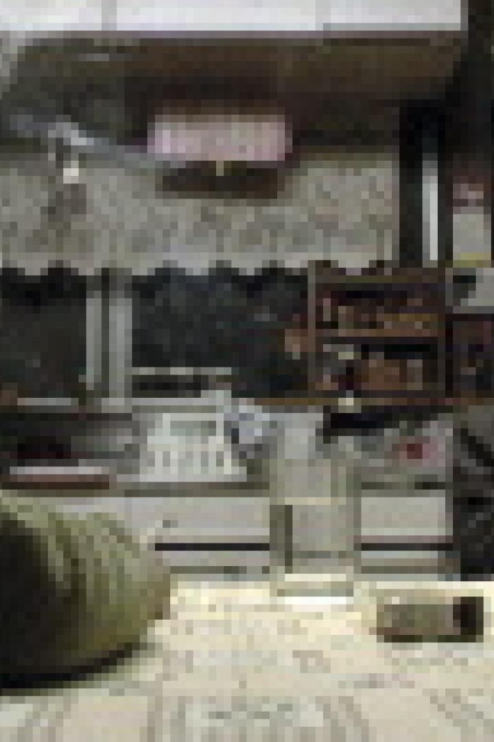 Zwei Männer sitzen an einem Tisch und rauchen Zigaretten.