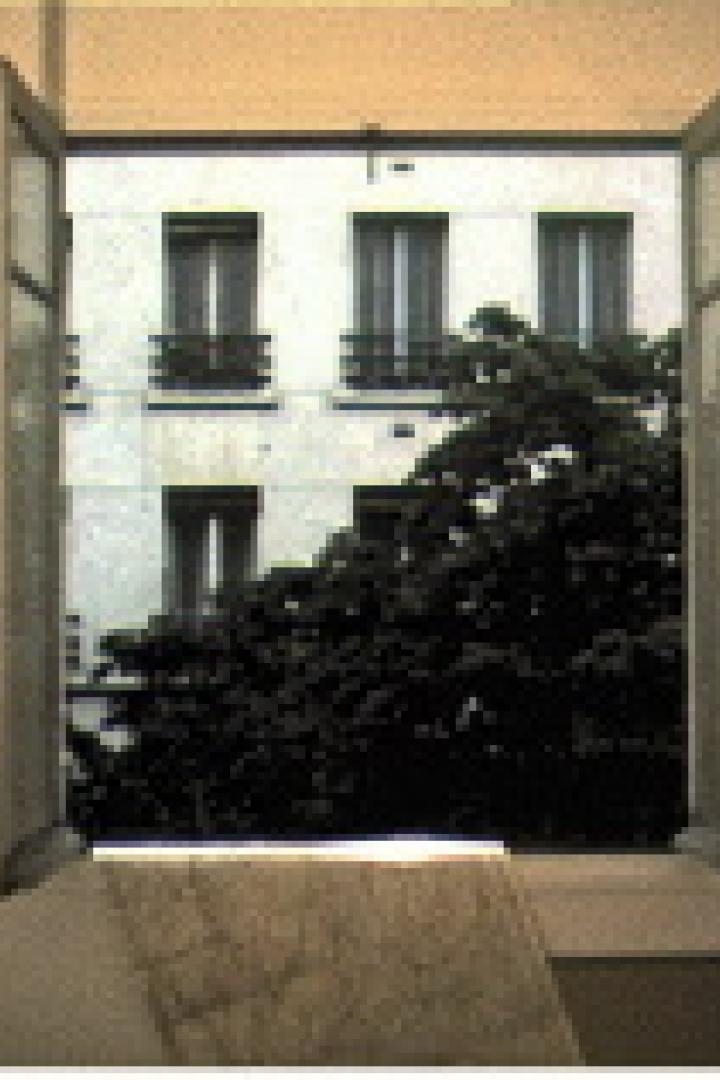 Ein offenes Fenster mit Blick auf ein Gebäude und einen Baum.