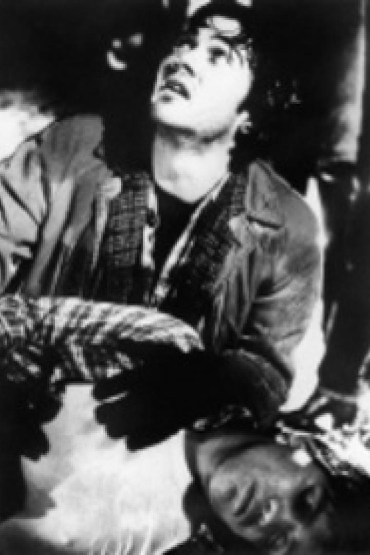 Eine junge Frau blickt besorgt nach oben, während sie eine andere Person stützt.