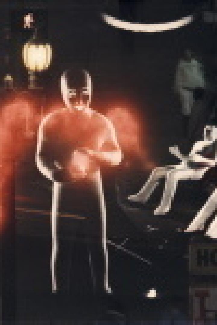 Eine beleuchtete Schaufensterpuppe steht vor einem Schaufenster mit anderen Schaufensterpuppen.