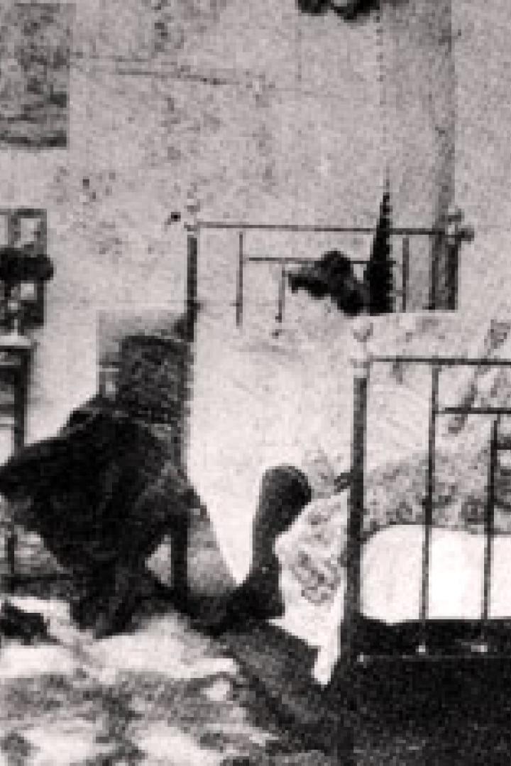 Ein Schlafzimmer mit zwei Betten und zwei Frauen, eine davon sitzt auf dem Bett.