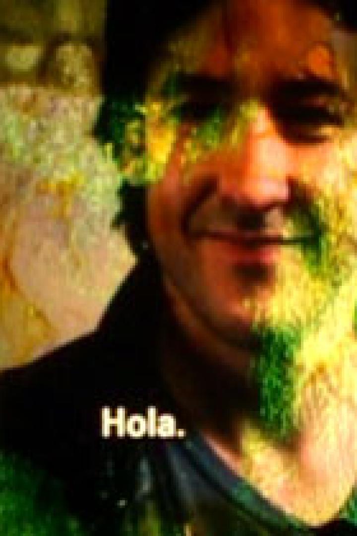 Ein Mann lächelt, sein Gesicht teilweise von Farbe bedeckt.
