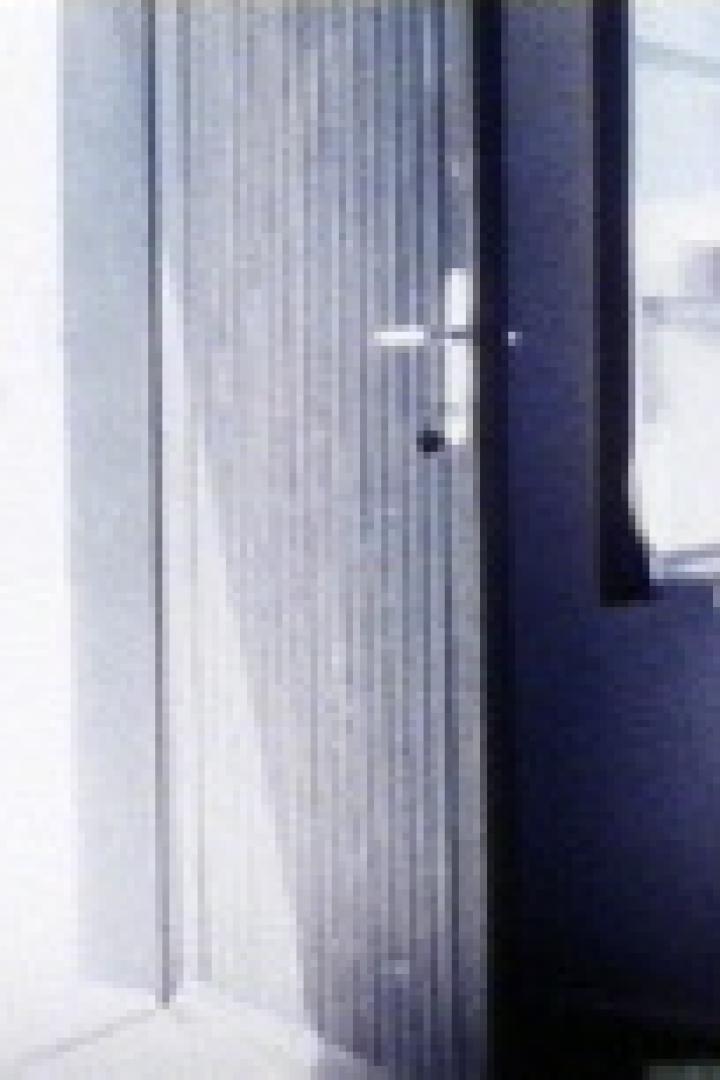 Eine offene Tür mit Blick nach draußen und ein Fenster mit wehenden Vorhängen.