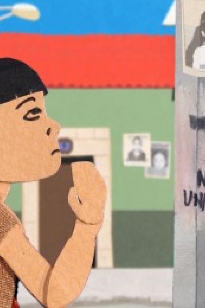 Eine junge Frau steht vor einem Pfosten mit dem Graffiti „Ni una más“.