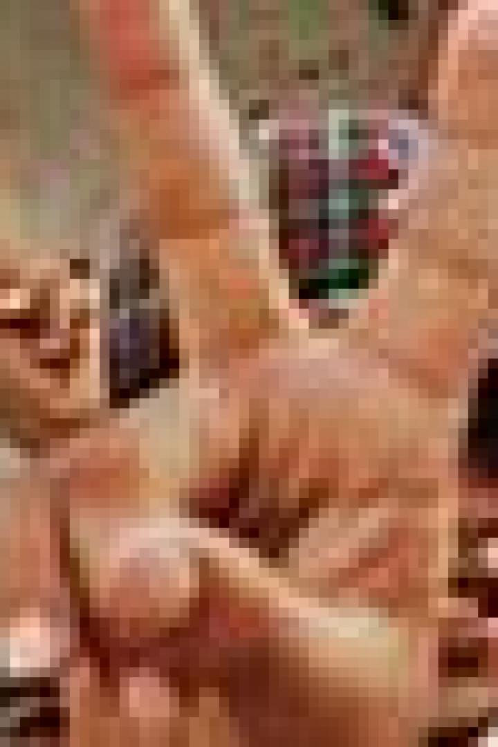 Eine Hand zeigt das Victory-Zeichen vor einer Gruppe junger Männer.