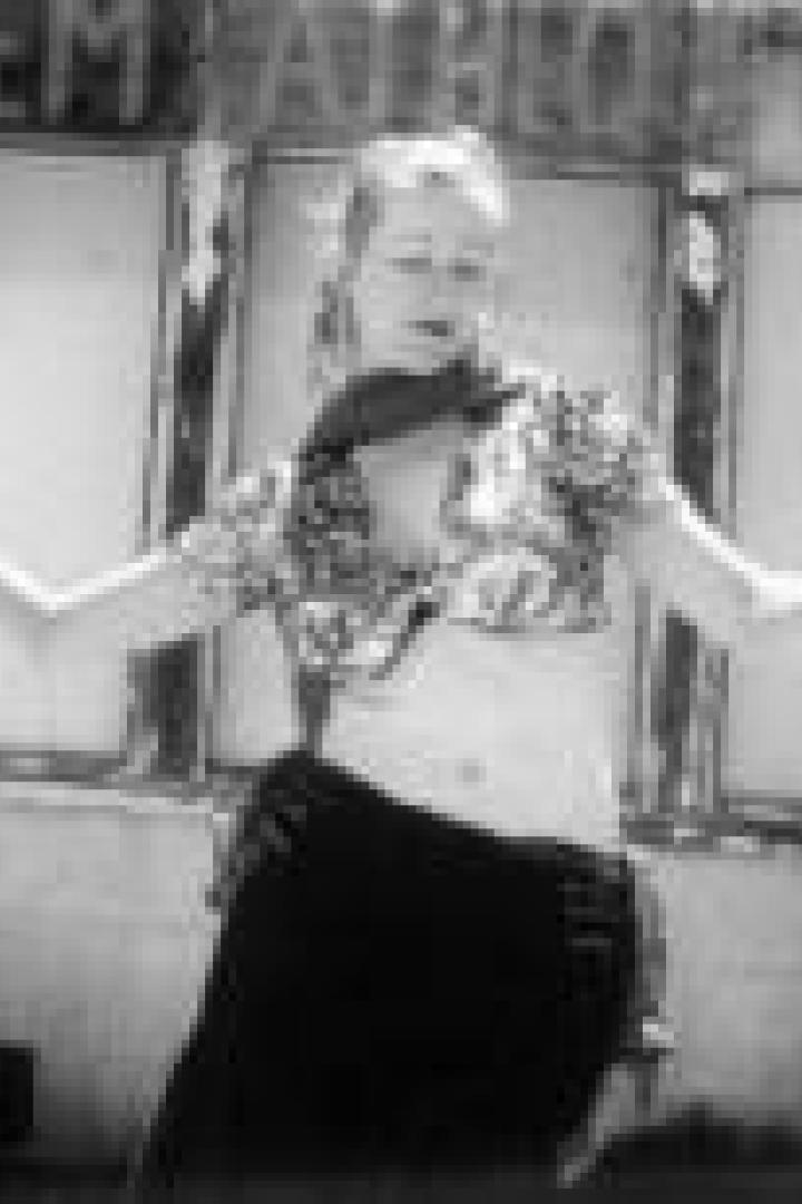 Eine Frau posiert vor einem alten Kino in der Wüste.