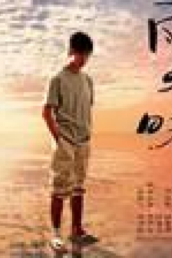 Ein junger Mann steht am Strand bei Sonnenuntergang. Im Vordergrund japanische Schriftzeichen.