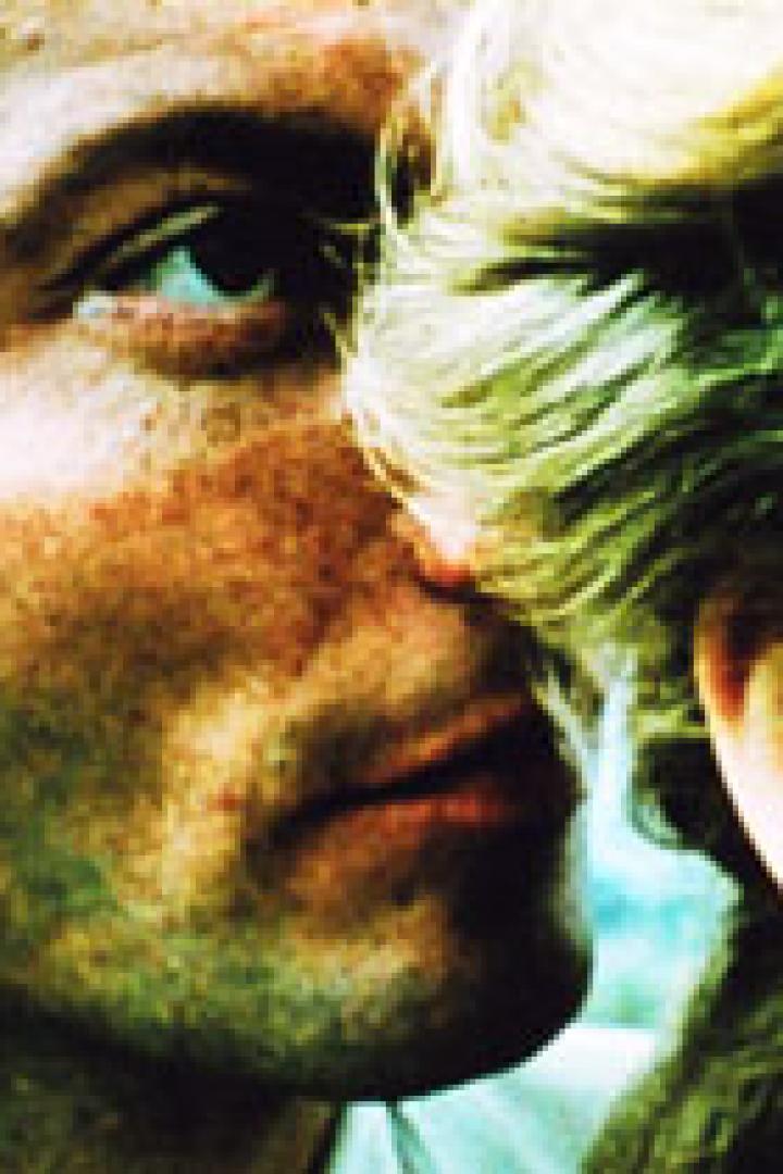 Ein Mann und eine Frau stehen einander sehr nah, fast Stirn an Stirn.