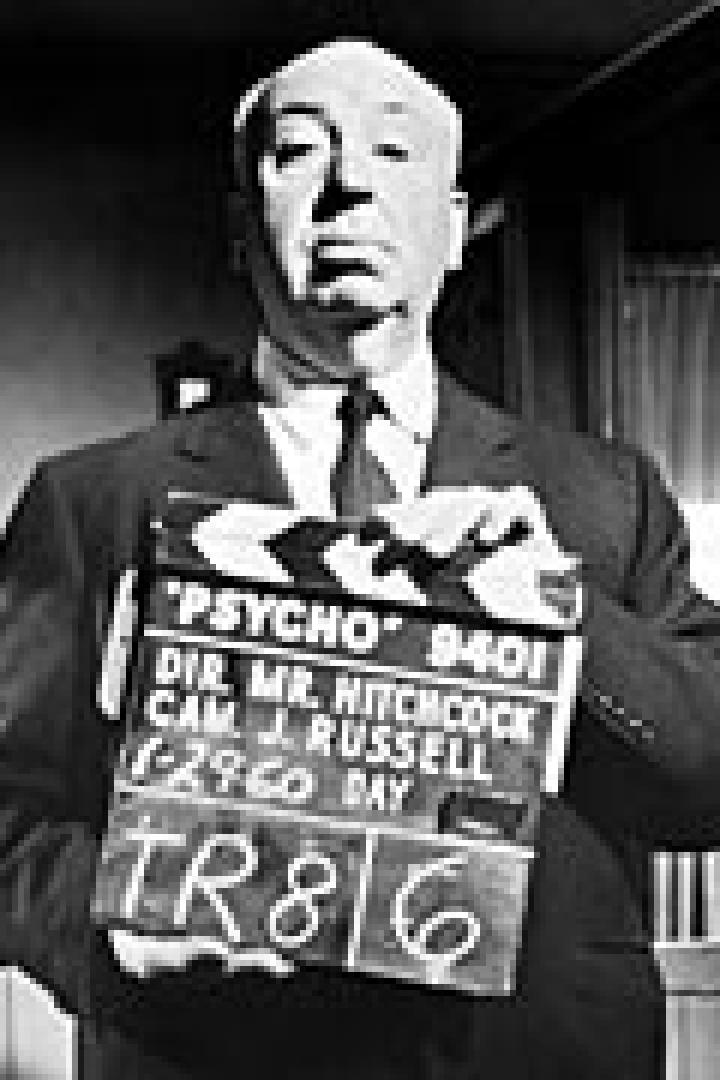 Alfred Hitchcock hält eine Filmklappe für den Film „Psycho“ in der Hand.