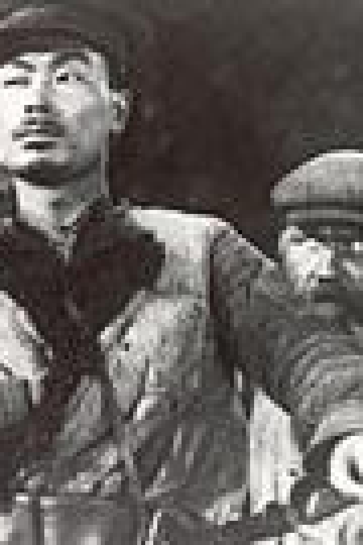 Ein Mann mit Mütze und ein Mann mit Bart stehen nebeneinander.