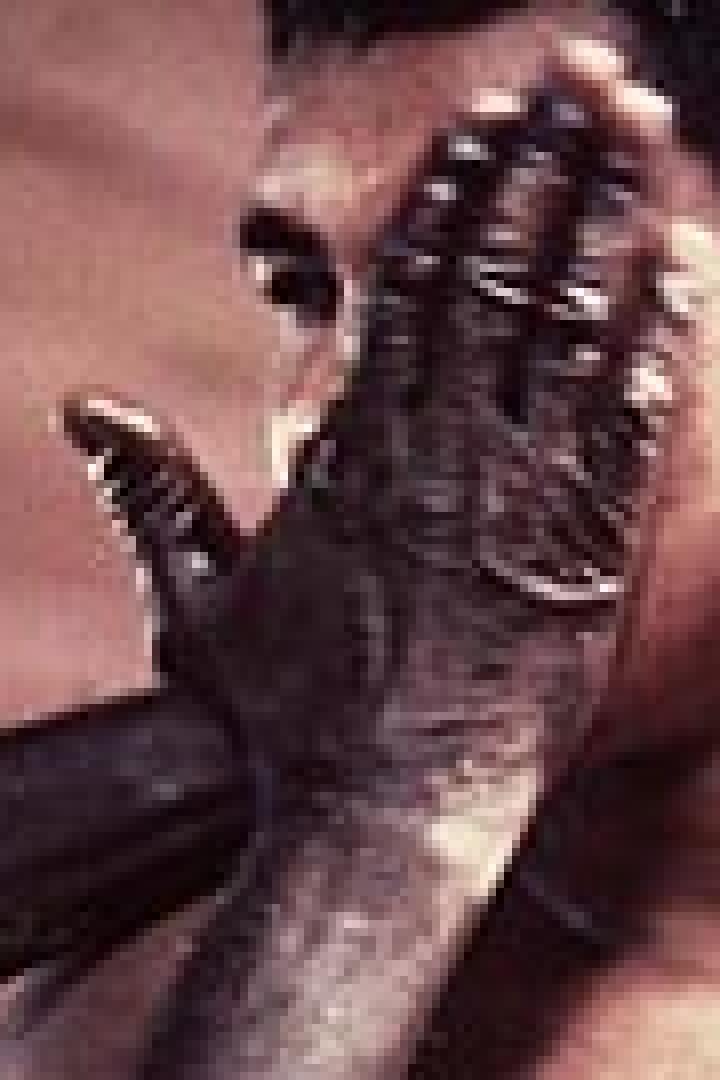 Muhammad Ali wird von einer dunklen Hand ins Gesicht gefasst.