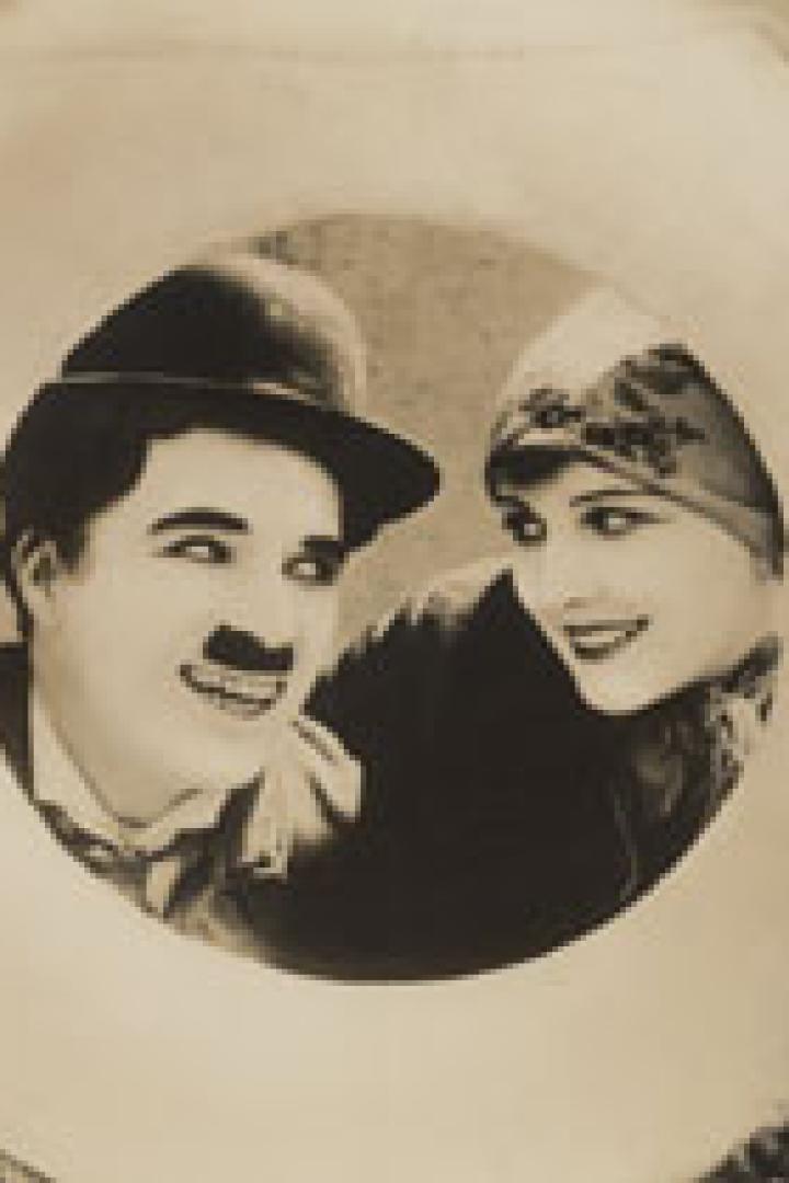Charlie Chaplin und eine Frau blicken durch einen Rettungsring.
